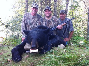 Group of hunters pose with their catch, black bear hunting group in Ontario