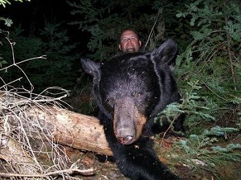 He poses with his black bear during a hunting trip