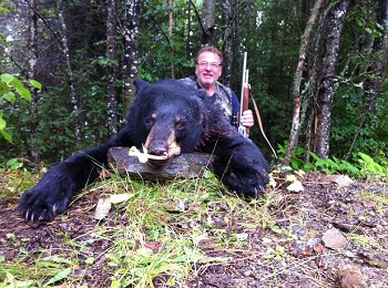 Hunter poses after catching a beautiful black bear