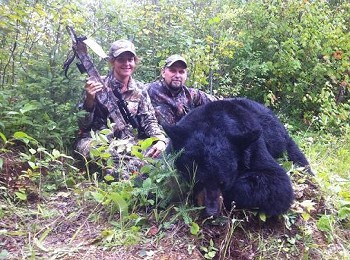 Hunters pose with a black bear from hunting trip